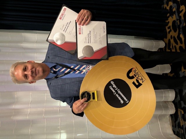 Joe Verkennes poses with awards.