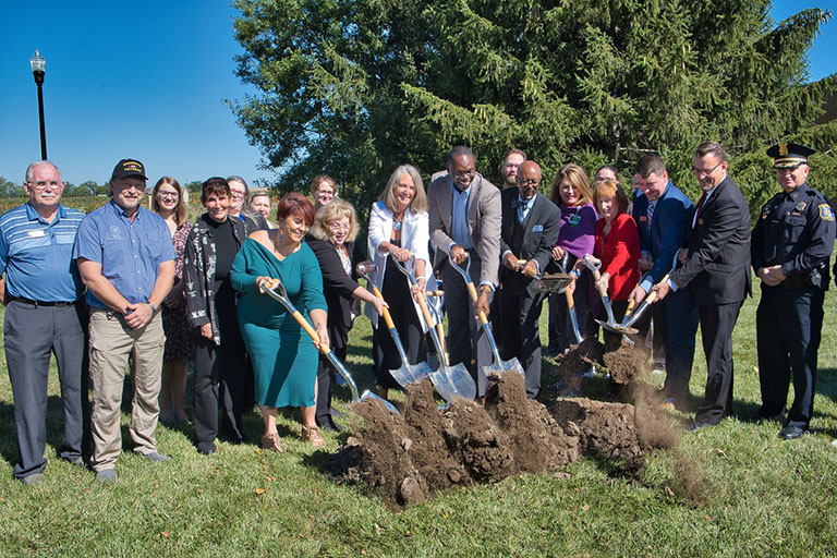 Politicians and employees in front of Welch Building with shovels for groundbreaking